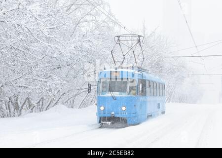Le tramway longe la rue pendant la tempête de neige en hiver à Moscou, en Russie. Froid et neige à Moscou. Tram glacé dans la neige de Moscou. Vue traditionnelle sur Mo Banque D'Images