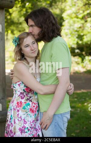 Embrassant jeune couple dans le parc lors d'une journée ensoleillée d'été, Springfield Park, Londres, modèle disponible Banque D'Images