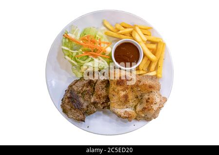 Steak de porc isolé recouvert de poivre noir et de poulet avec frites et salade dans un plat sur fond blanc avec un chemin de coupure. Banque D'Images