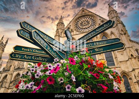 Le York Minster et un panneau indiquant les directions vers les sites touristiques de la ville - au coucher du soleil Banque D'Images