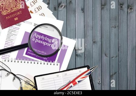 Guide violet anglais la demande de passeport est sur la table avec des articles de bureau. Procédure de documentation des passeports au Royaume-Uni Banque D'Images