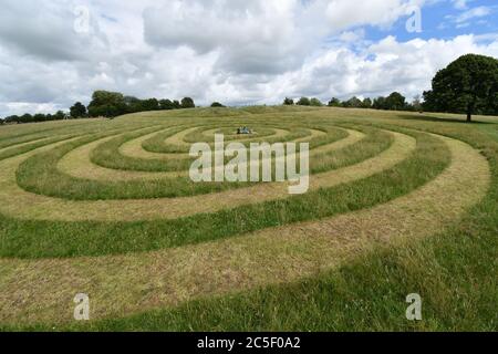 Les enfants jouent au centre de la trajectoire en spirale coupée dans l'herbe sur l'ancien champ d'exposition de fromage à Frome Somerset.UK Banque D'Images