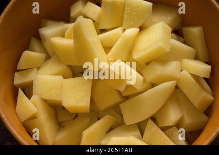 Préparation de la soupe. Tranches de pommes de terre dans une assiette en céramique orange. Vue de dessus Banque D'Images