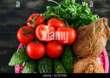 Mélanger les légumes .tomate, Quora, karela, dans le panier sur table en bois noir Banque D'Images