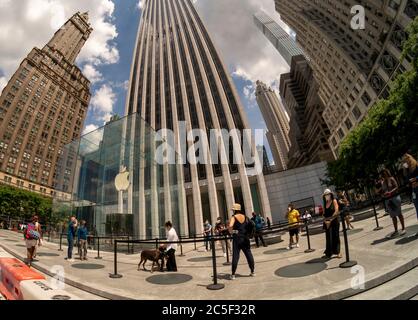 Clients et travailleurs à l'extérieur de l'Apple Store récemment ouvert sur Fifth Avenue à New York le dimanche 21 juin 2020. Les magasins ont un personnel de nettoyage dédié et sont approvisionnés en masques, assainisseurs et iPhones, (© Richard B. Levine) Banque D'Images