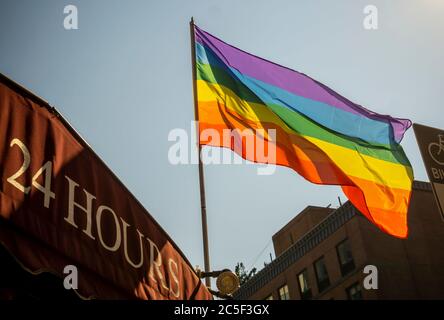 Un drapeau arc-en-ciel vole d'une entreprise à New York le mardi 23 juin 2020. En raison de la pandémie de Covid-19, le défilé de la fierté LGBTQ de cette année, ainsi que tous les autres grands rassemblements, ont été annulés ou reportés. (© Richard B. Levine) Banque D'Images