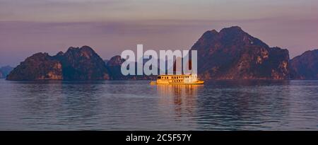 Soleil matinal sur le bateau de plaisance touristique dans la baie d'Ha long parmi les karsts de calcaire Banque D'Images