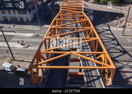 Vue aérienne du pont piétonnier sur la route et les voies de tramway dans le quartier de Jatkasaari, Helsinki, Finlande. Banque D'Images