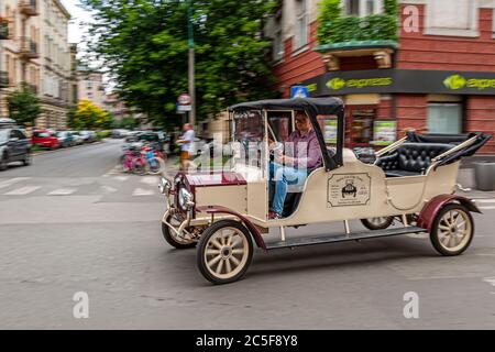 Une voiture classique traverse Cracovie pour des visites de la ville en voiture rétro. Voyage dans les vieilles impressions de StyleKraków, Cracovie, Pologne Banque D'Images