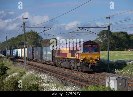 DB locomotive diesel de classe 66 66137 sur la ligne principale de la côte ouest électrifiée avec un train de fret à conteneurs intermodal Banque D'Images