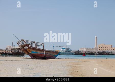 Al Ruwais, Al Shamal, plage et village de pêcheurs dans le nord du Qatar. Pêche traditionnelle Dhow bateaux, avec une mosquée en arrière-plan. Banque D'Images