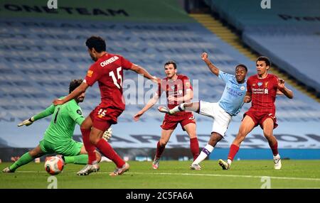 Raheem Sterling de Manchester City tire et Alex Oxlade-Chamberlain de Liverpool place le ballon dans son propre but pour le quatrième but de Manchester City lors du match de la Premier League au Etihad Stadium de Manchester. Banque D'Images