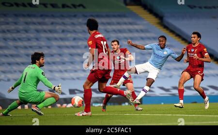 Raheem Sterling de Manchester City et Alex Oxlade-Chamberlain de Liverpool détournent le ballon dans son propre but pour le quatrième but de Liverpool lors du match de la Premier League au Etihad Stadium de Manchester. Banque D'Images