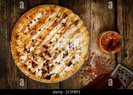 Tarte à la crème sautée et au caramel salé sur fond de bois rustique. Banque D'Images