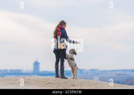 jeune femme jouant avec son chien à l'extérieur Banque D'Images