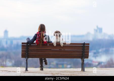 femme et son chien assis sur le banc dans le parc Banque D'Images