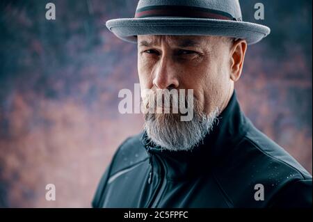 Homme plus âgé avec une barbe grise portant un fedora Banque D'Images