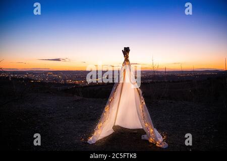 Tipi au sommet de la colline avec une petite chaîne de lumière à l'intérieur de la tente pendant le coucher du soleil avec vue sur le paysage Banque D'Images