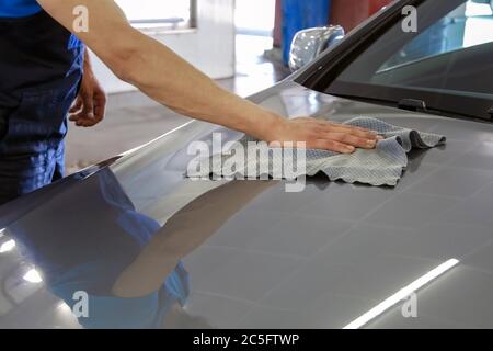 La rondelle de voiture homme lingettes et produits à polir un capot de voiture après le lavage avec un chiffon spécial Banque D'Images