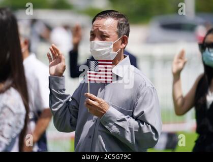 Hazelwood, États-Unis. 02 juillet 2020. Phu Cong Phung, du Vietnam, a prêté serment en tenant son drapeau américain, assermenté en tant que citoyen américain, lors d'une cérémonie de naturalisation à Hazelwood, Missouri, le jeudi 2 juillet 2020. 54 les pétitionnaires ont prêté serment, car ils se sont tenus à l'extérieur, à des températures de 90 degrés, en prenant des distances sociales et en portant des masques. Photo de Bill Greenblatt/UPI crédit: UPI/Alay Live News Banque D'Images