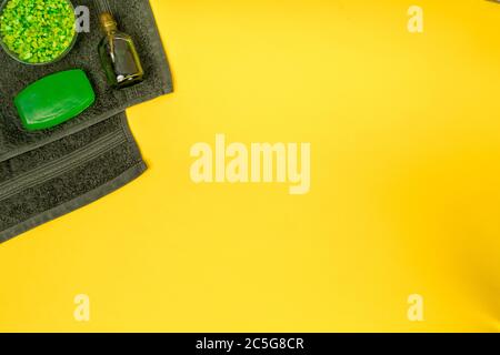 Ensemble de spa : savon, masque, huile, sel de mer et serviette sur fond jaune Banque D'Images