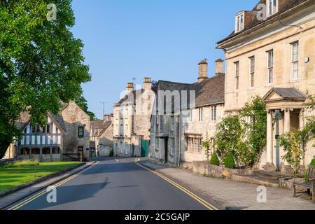 Maisons de ville en pierre de Cotswold et église St Marys lychgate au lever du soleil. Painswick, Cotswolds, Gloucestershire, Angleterre Banque D'Images