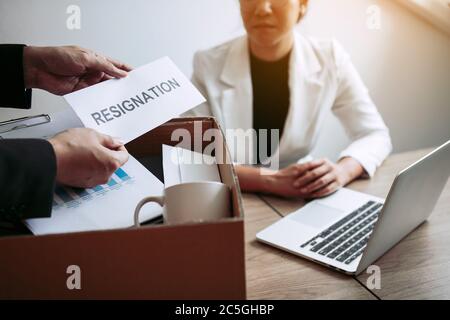 L'employé prend le manche à l'enveloppe de démission tout en étant remis à la femme gestionnaire. Banque D'Images