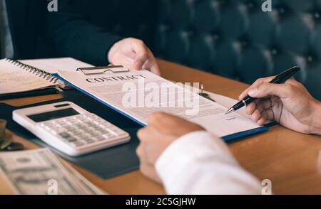Le personnel de vente de biens immobiliers soumet des documents de contrat d'hypothèque foncière aux acheteurs de maison pour signature. Banque D'Images
