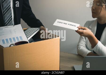 La gestionnaire féminine soumet une lettre de démission ou une enveloppe à l'employé masculin du bureau. Banque D'Images