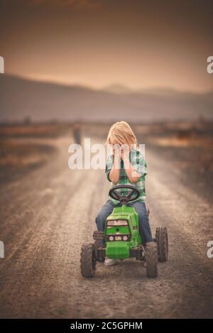 garçon conduite tracteur jouet concept d'une enfance heureuse Banque D'Images