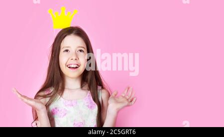 Petite princesse fille, couronne, isolée sur fond rose. Enfant porter le symbole de couronne dorée princesse. Petite princesse. Fille porte couronne rose fond Banque D'Images