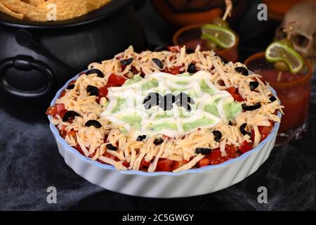 Spooky Halloween Seven Layer Taco Dip Transformer un apéritif classique en favori d'Halloween avec juste un peu d'art crème aigre et un d'olive noire Banque D'Images