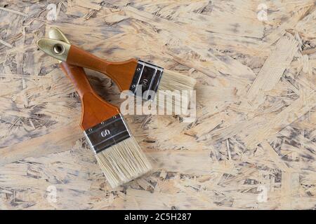 deux brosses sont préparées pour la réparation et la peinture, sur une plaque en bois Banque D'Images