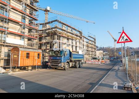 Immeuble inachevé avec véhicules de construction, échafaudage et panneau de chantier Banque D'Images