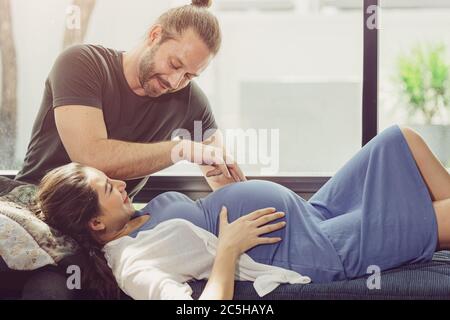 Pregnantcy femme rester à la maison avec un mari adorable jouant avec le ventre de bébé. Banque D'Images