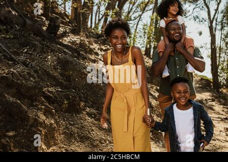 Une famille joyeuse qui s'est promenée sur un sentier de montagne. Parents et deux enfants qui font de la randonnée dans le parc national. Banque D'Images