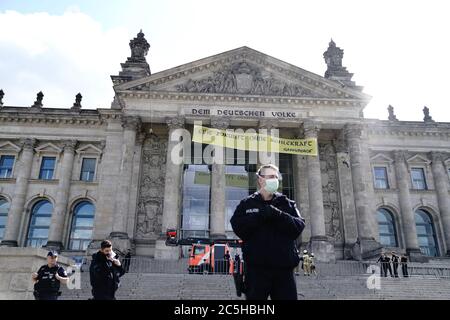 Berlin, Allemagne. 03ème juillet 2020. Les policiers se tiennent devant le bâtiment du Reichstag, tandis que les militants de Greenpeace se sont rabadis du bâtiment avec une bannière disant « UN avenir sans charbon », et les pompiers sont au sol à côté d'un camion d'incendie. Le Bundestag va adopter une loi d'élimination du charbon aujourd'hui. Credit: Kay Nietfeld/dpa/Alay Live News Banque D'Images