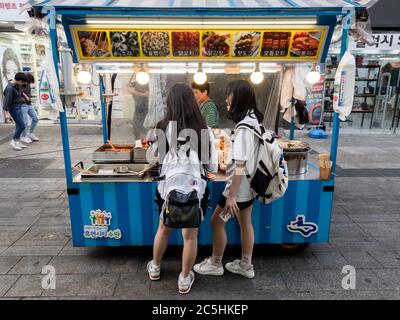 Suwon, Corée du Sud - 15 juin 2017 : deux jeunes femmes achètent des fast-food dans le kiosque de fast-food de la rue principale de Suwon. Banque D'Images