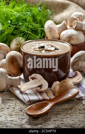 Soupe à la crème avec champignons champignon dans un bol, composition de style vintage sur une table rustique en bois. Banque D'Images
