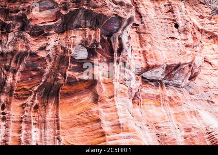 La surface rocheuse en grès rouge du canyon appelée Al Siq à l'entrée de la ville rose de Petra en Jordanie. Banque D'Images