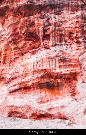 La surface rocheuse en grès rouge du canyon appelée Al Siq à l'entrée de la ville rose de Petra en Jordanie. Banque D'Images