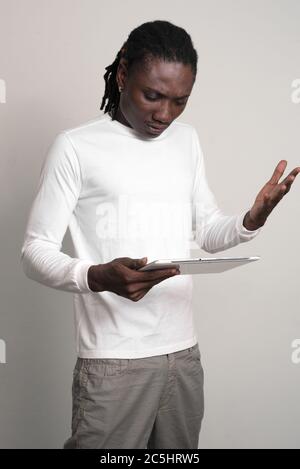 A souligné le jeune homme africain avec des dreadlocks utilisant la tablette numérique Banque D'Images