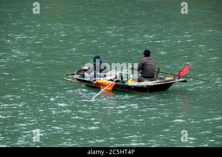 Ha long Bay Vietnam, hommes locaux en petit bateau en bois pêche durable Banque D'Images