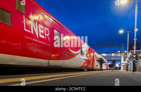 TRAIN à grande vitesse LNER attendant à une gare sur la ligne principale de la côte est, Angleterre, Royaume-Uni. Banque D'Images