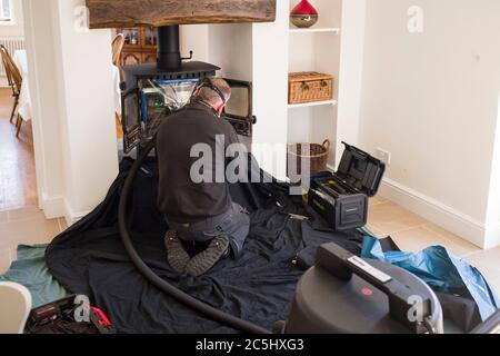 BUCKINGHAM, Royaume-Uni - 20 avril 2020. Homme balayant poêle à bois et cheminée avec un conduit de fumée dans une maison, Royaume-Uni Banque D'Images