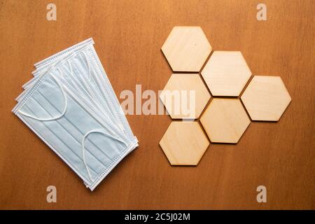 Concept de soins de santé épidémique, masque médical et Résumé hexagonal sur fond de table en bois. Banque D'Images