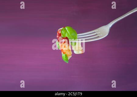 Cuisine italienne. Pâtes penne à la sauce tomate et basilic sur la fourchette Banque D'Images