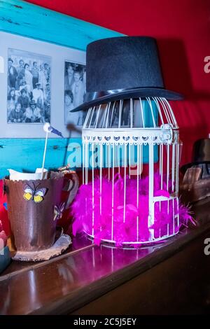 Thé coloré avec table mise en place de décorations de fantaisie de chapeaux, théières et cage d'oiseau ornemental Banque D'Images