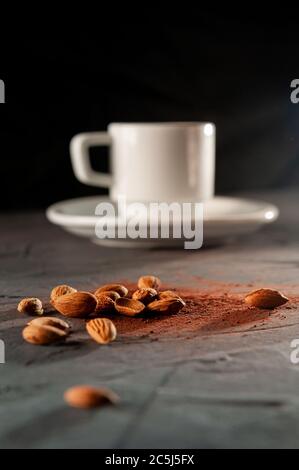 fèves de cacao avec une tasse sur fond gris foncé Banque D'Images