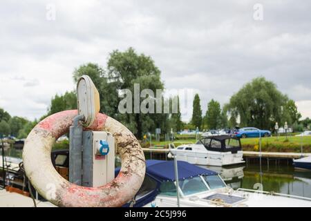 Prise électrique étanche connectée à un câble alimenté dans une marina de plaisance. Banque D'Images